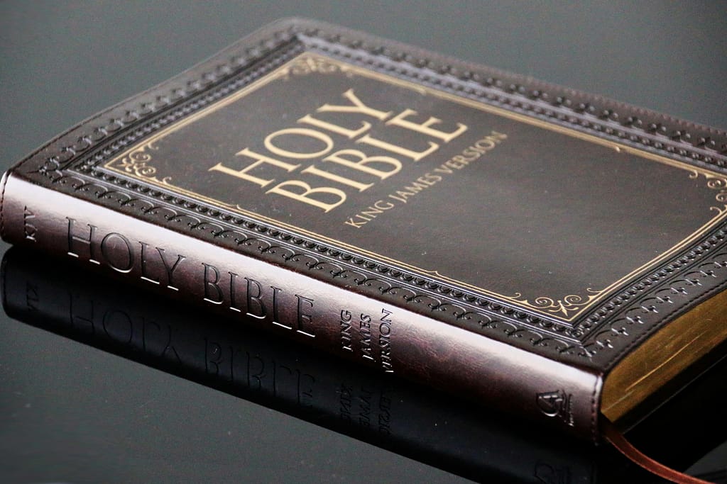 pexels photo 8268312 8268312 Close-up view of a leather bound King James Version Holy Bible resting on a reflective surface.